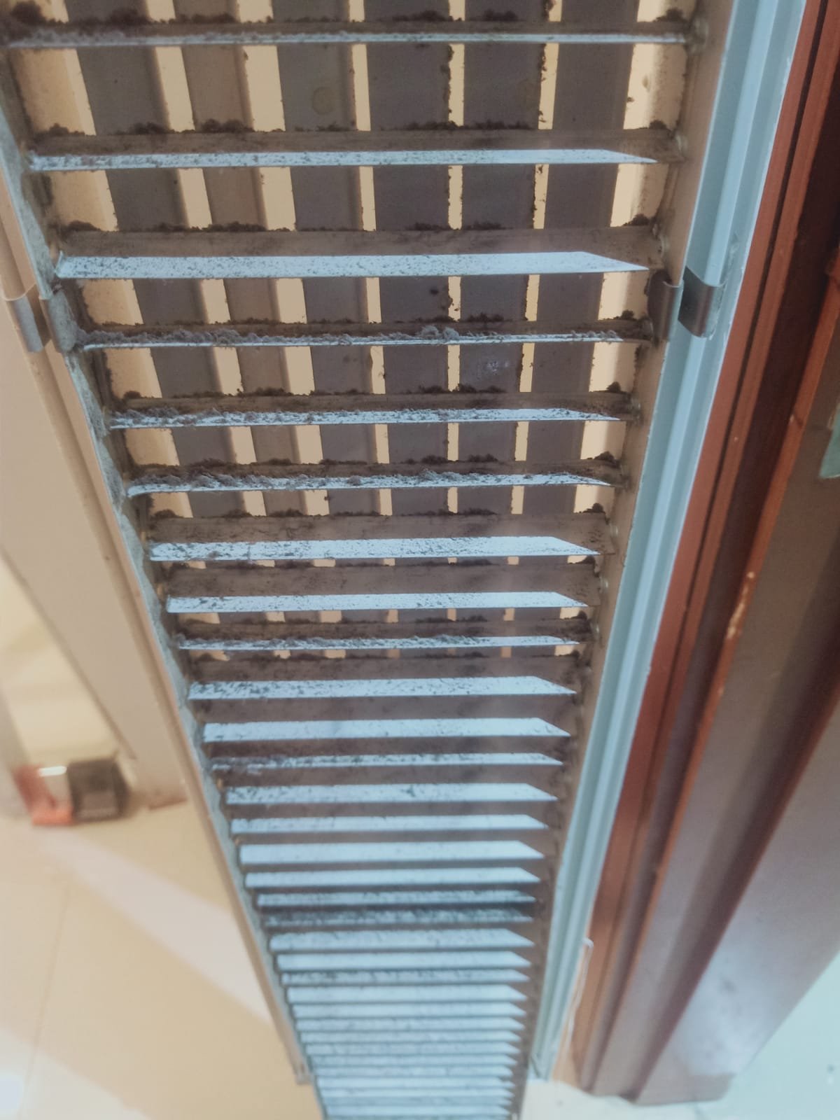 Dust buildup on an air-conditioning grille before cleaning